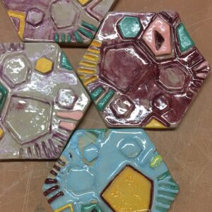 A photo of four hexagonal ceramic tiles with a colourful