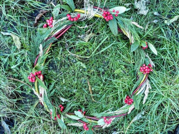 A finished wreath lying on some grass.
