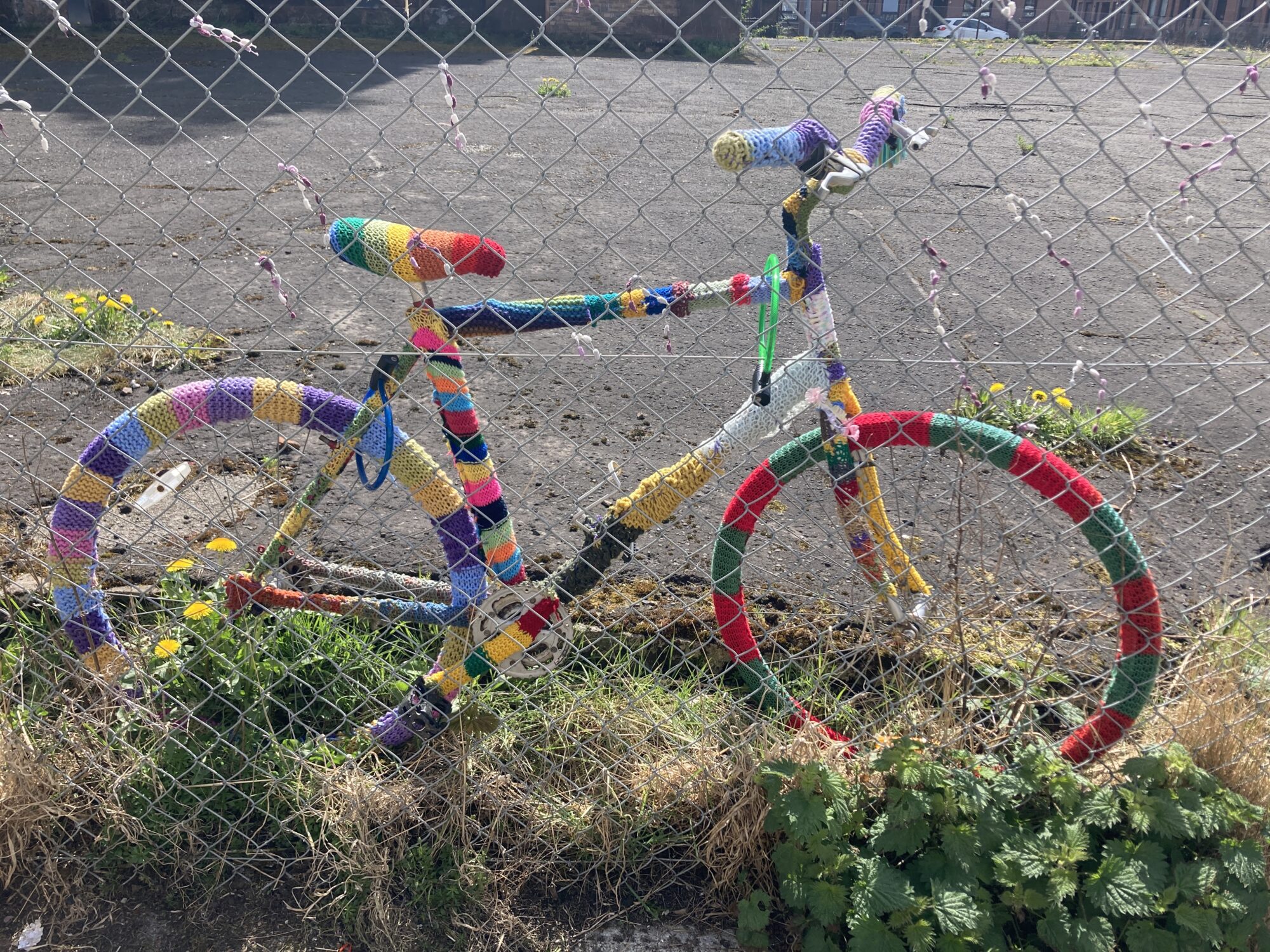 An abandoned bike that has been covered in colourful thread