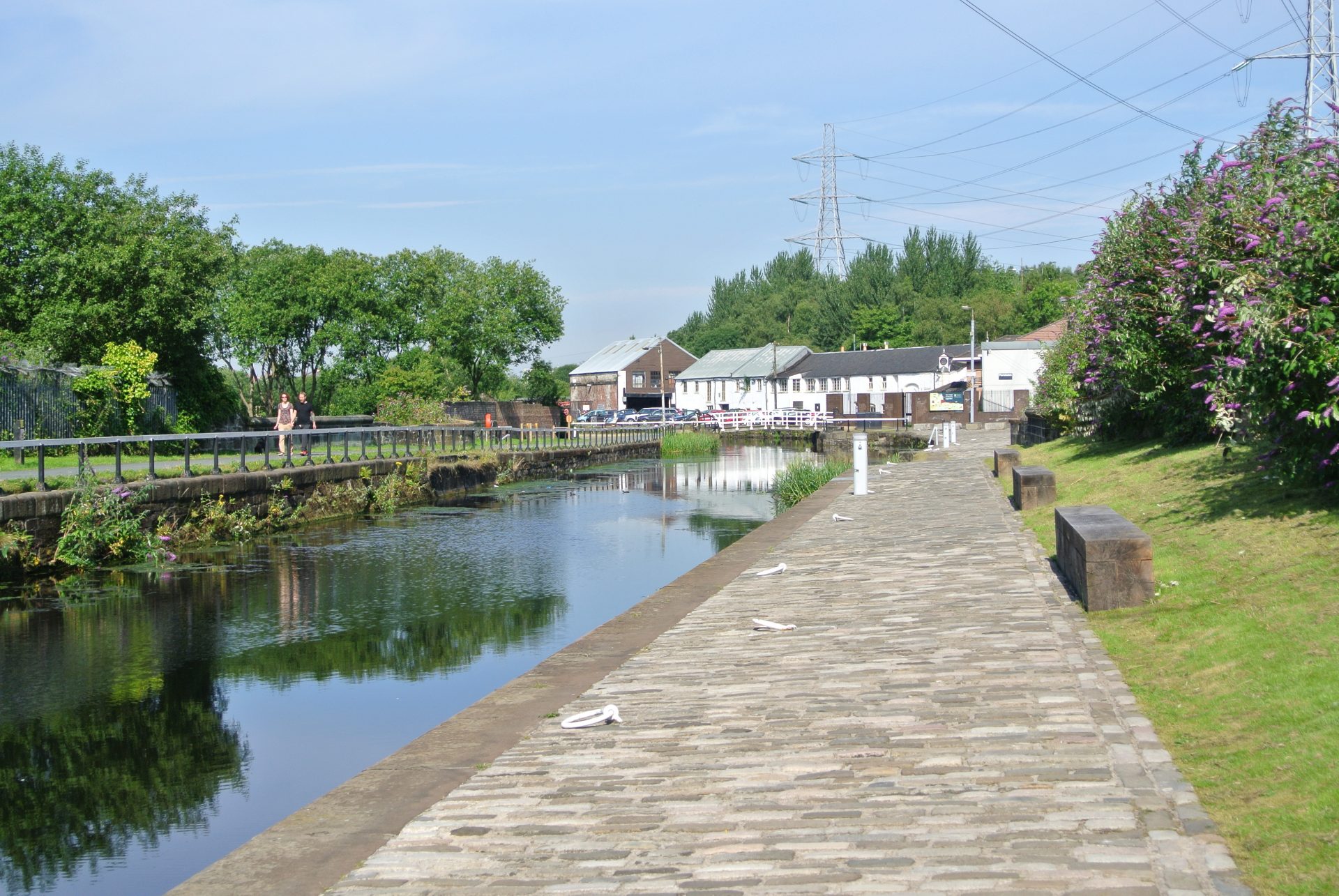 A view of the Forth & Clyde Canal, with towpath in foreground and buildings in the background