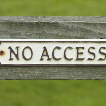 "No Access" sign on wooden fence, on green background